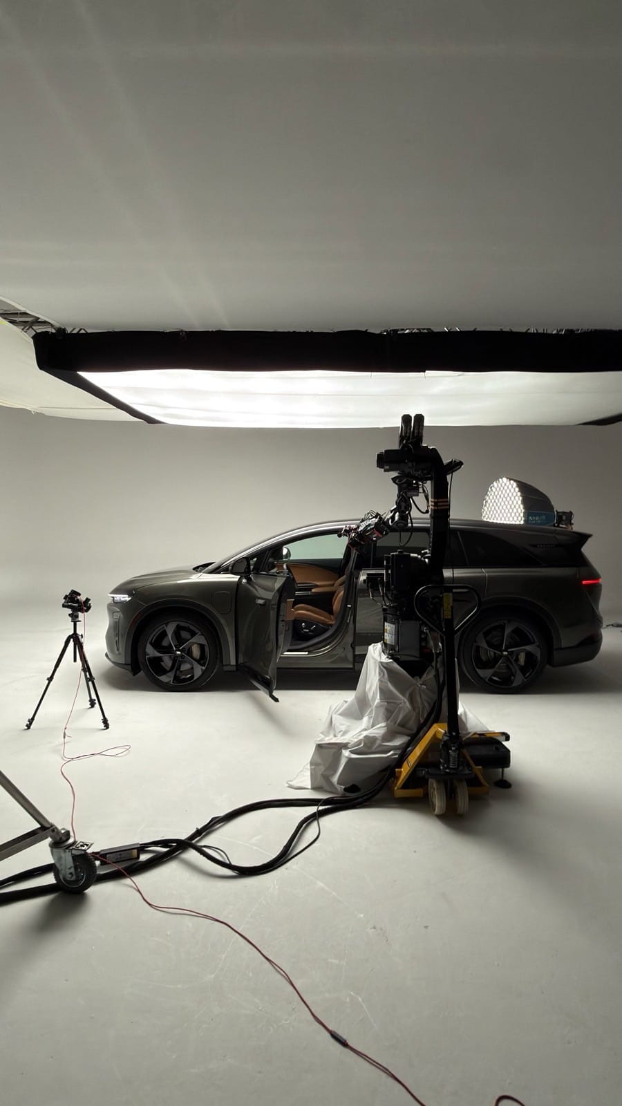 Lucid Gravity on a white cyclorama beside a robotic motion-control camera system and overhead diffusion.