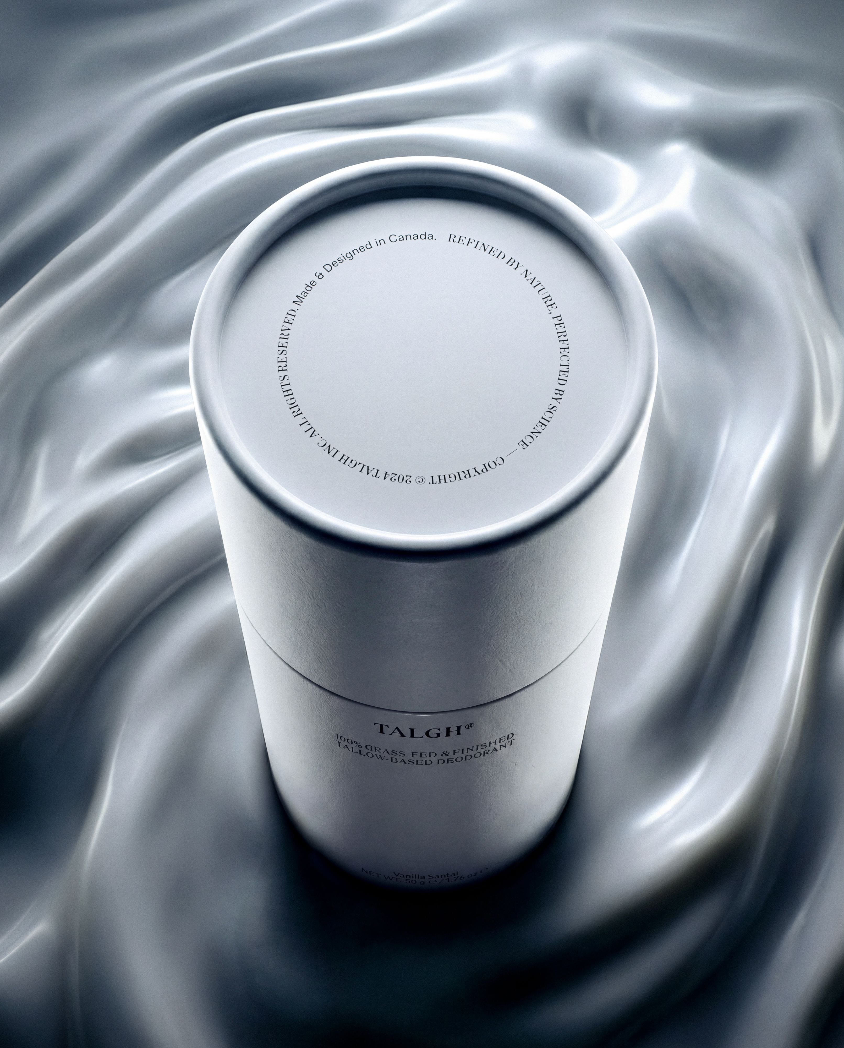 Talgh Essential Deodorant standing within soft silver ripples that evoke its creamy vanilla and sandalwood notes.